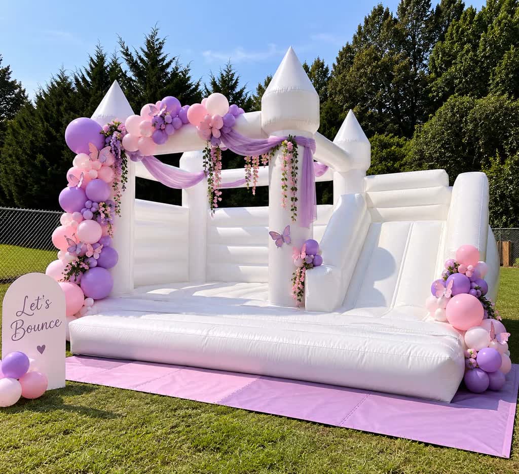 White bounce house with slide decorated with a pink and lavender balloon garland, butterflies and a Let's Bounce sign on a pink mat — event rentals in Braselton, GA