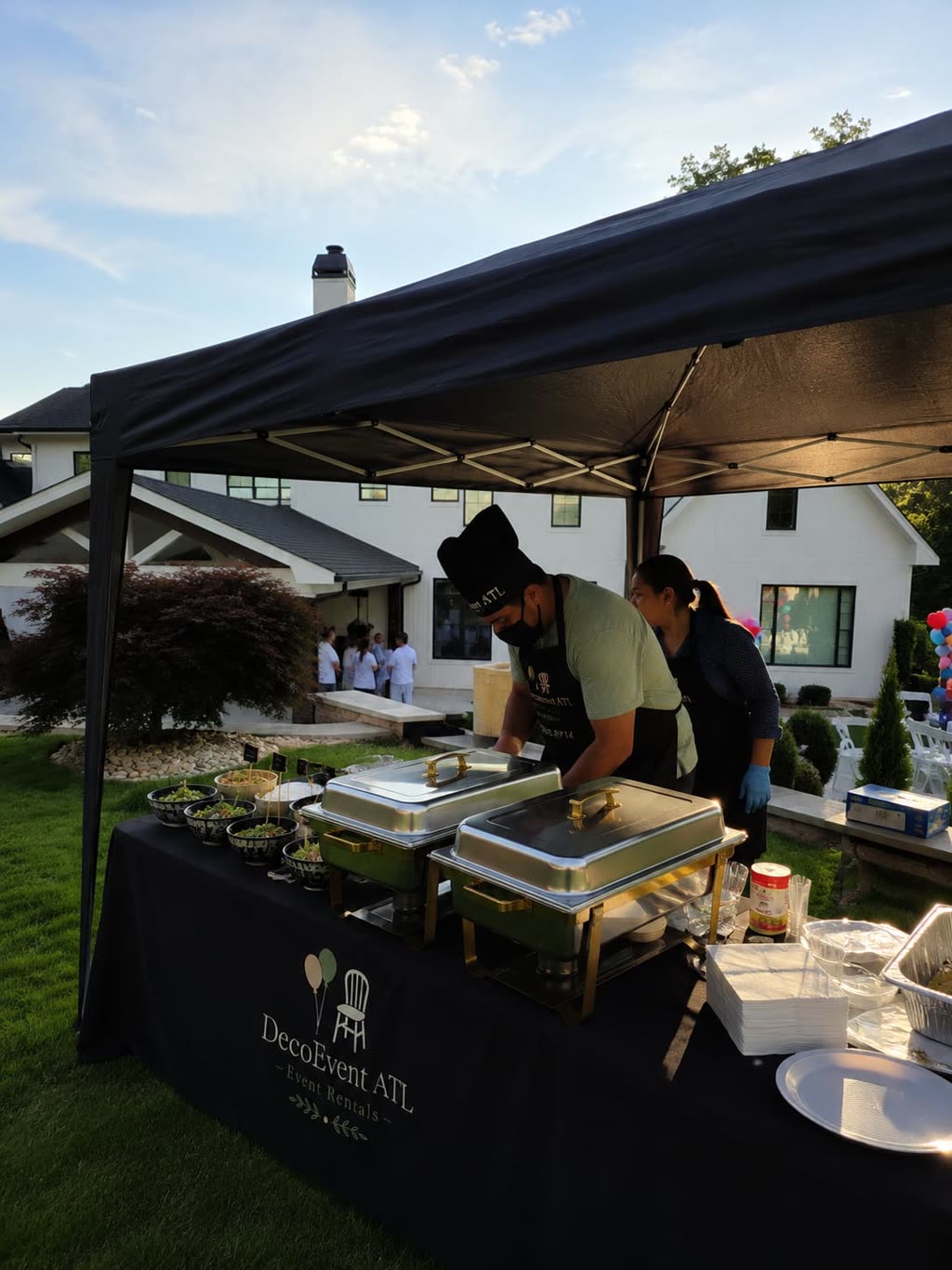 Uniformed DecoEvent ATL cooks serving guisados from the plancha at a taco station