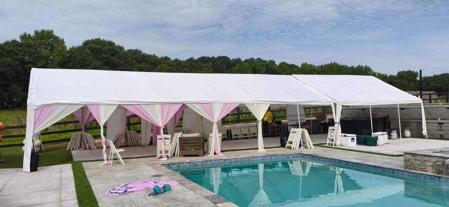 Long tent with pink and cream draping installed beside a pool