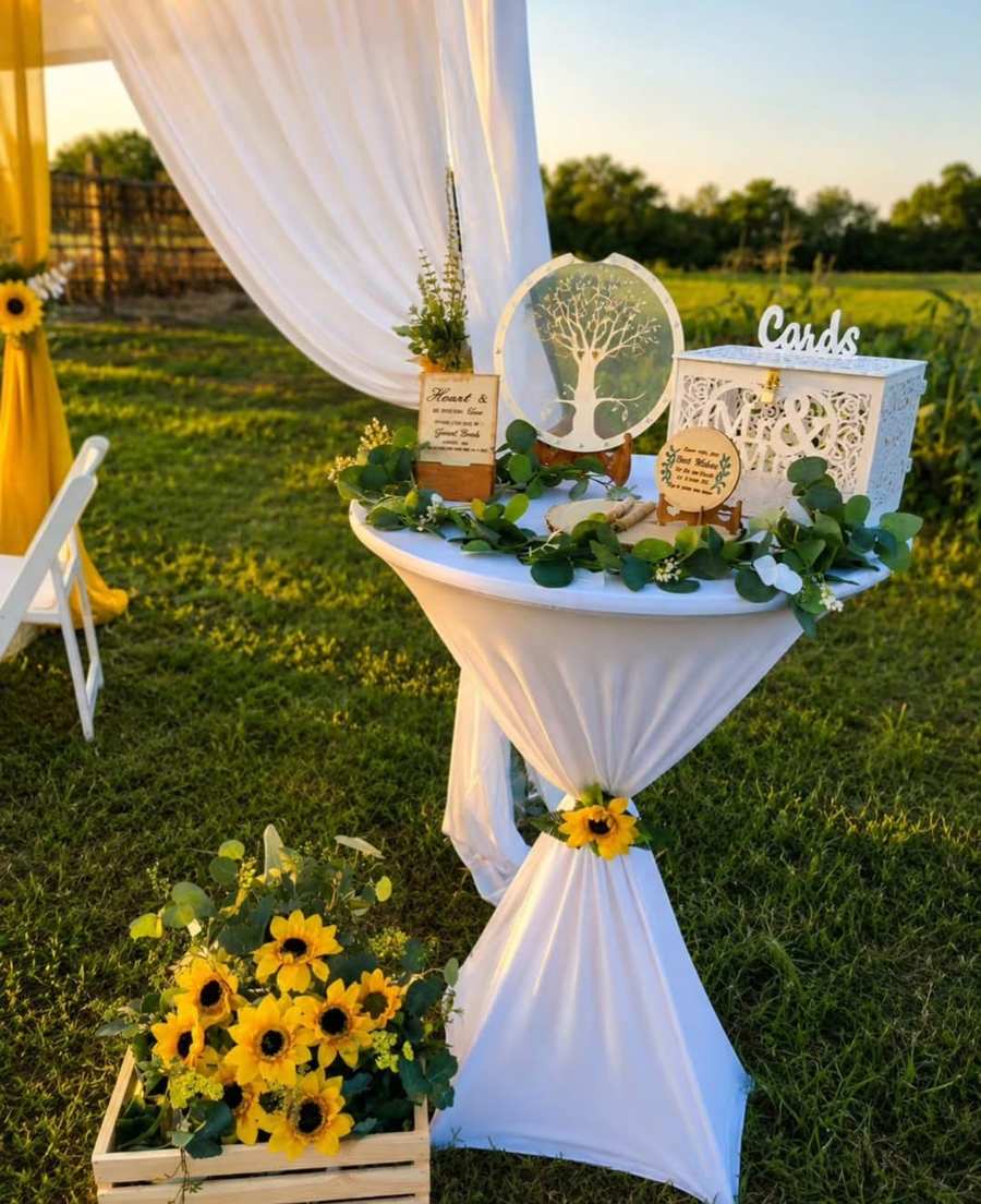 Cards table with sunflowers and draping at an outdoor wedding
